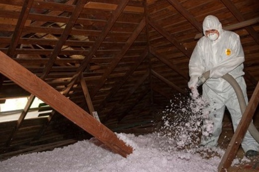 worker installing attic insulation.