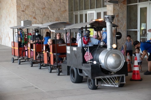 Image of parents and children riding a train at a previous Austin Train Show.