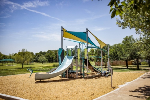 a playground with attached coverings in a park