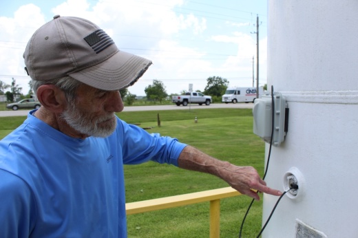 a man points to a hose connected to a propane tank
