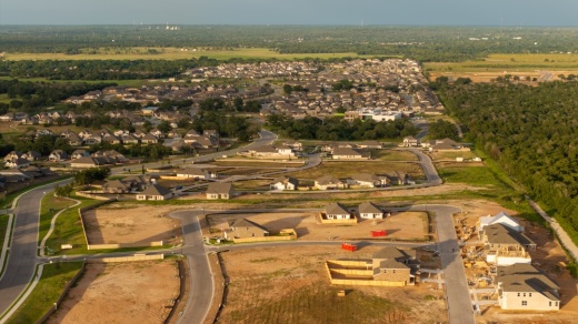 An aerial view shows rows of homes, both new and under construction.
