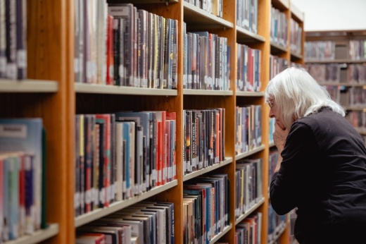Senior browsing books in library