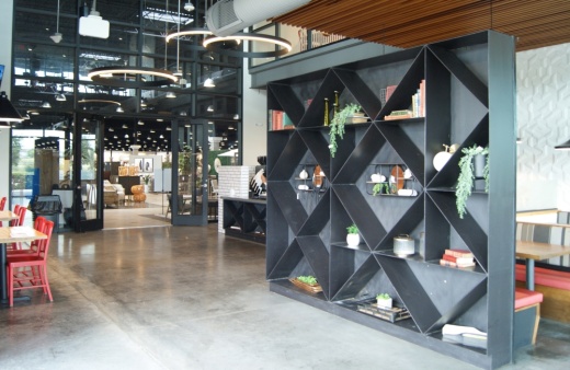 A black shelf organizer and red chairs are inside the newest Living Spaces Café.