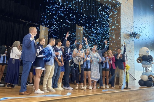 People cut a ribbon with confetti flying
