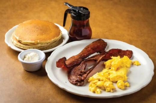 An image of pancakes, bacon and eggs served at the restaurant.