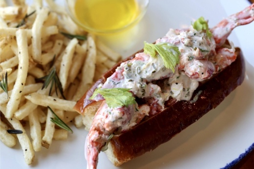 Lobster roll with side of fries and cup of melted butter.