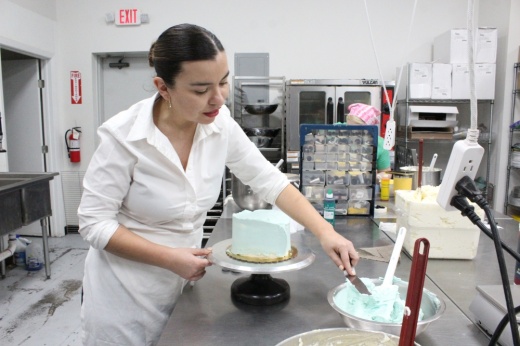 Nelia Shehaj-Valdez frosting a cake