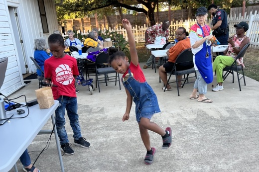 Two children dancing in the foreground outside the center.