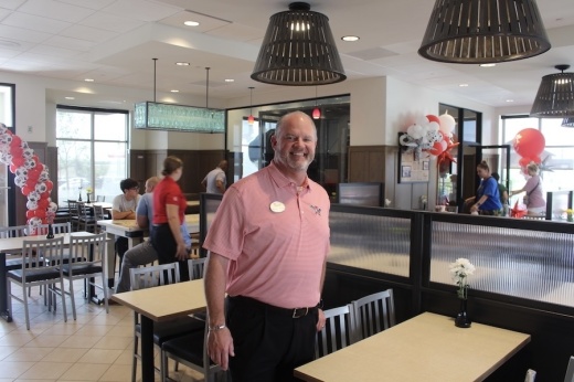 Picture of a man in a dining room of a restaurant.