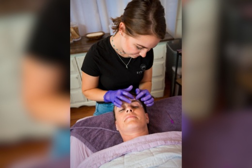 An image of a worker at the spa massaging someone's face.