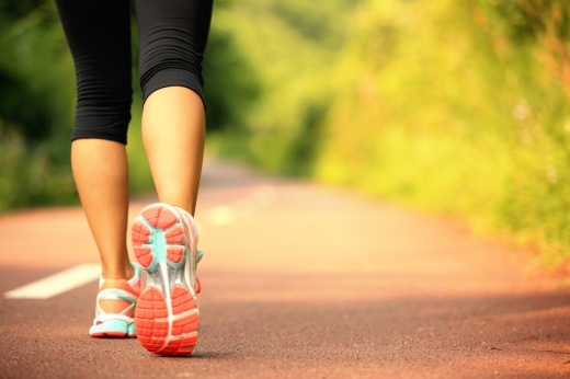a woman walks down a trail.