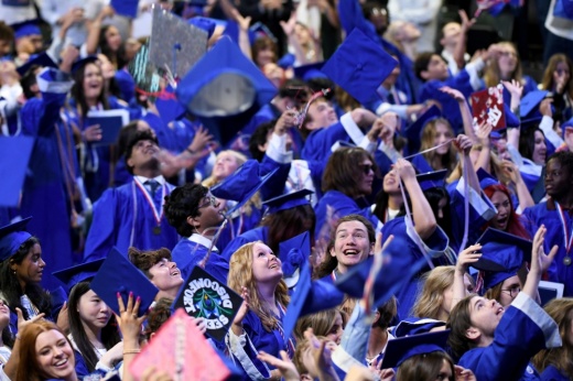 Graduates throw their caps into the air
