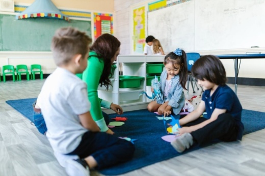 An image of a teacher playing with children.