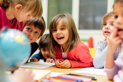 A photo of children laughing at a table.