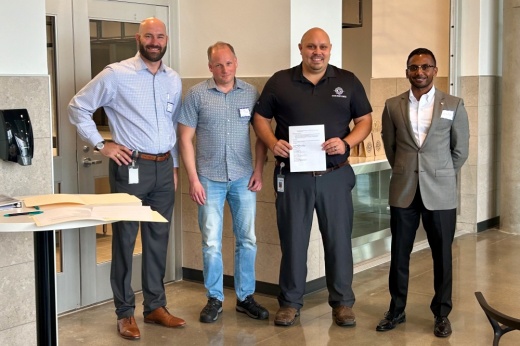 From left, Wes Vanicek, GISD's chief of construction services and future ready initiatives; Peter Stone, vice president of process engineering at CelLink; Bretton Schulz, GISD career and technology education director; and GISD Superintendent Devin Padavil signed on to a partnership to create a new manufacturing pathway in the district Sept. 17. (Brooke Sjoberg/Community Impact)