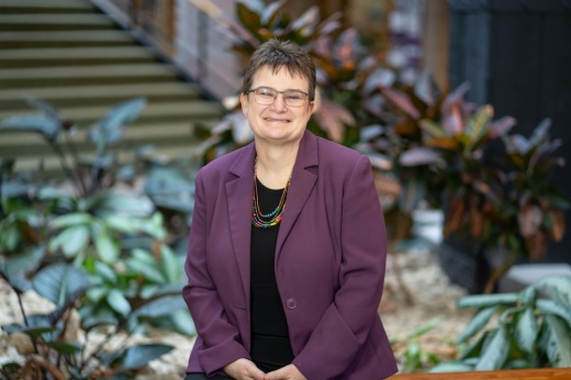 Headshot of Kristi Kirk with short hair, glasses and a purple blazer