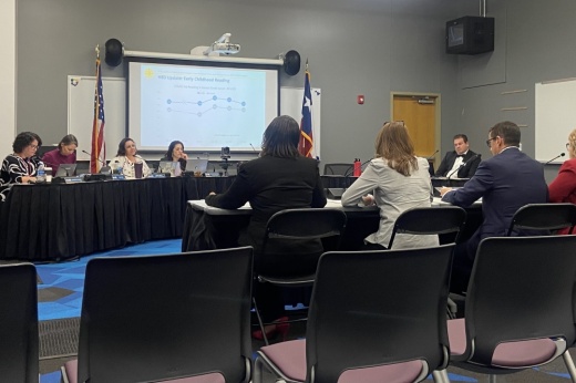 District officials sit at a table presenting to the board of trustees