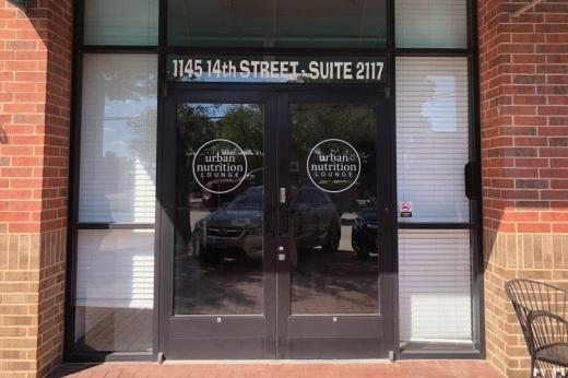 Exterior of brick building with Urban Nutrition Lounge signage on glass doors.