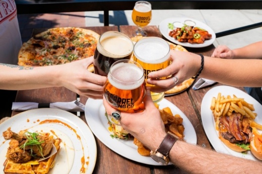 Three people holding up drinks