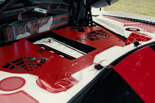 The underside of the hood of a red hot road is shown from a previous car show in Bastrop.