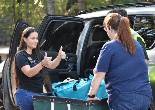 Volunteers unload donations from a car