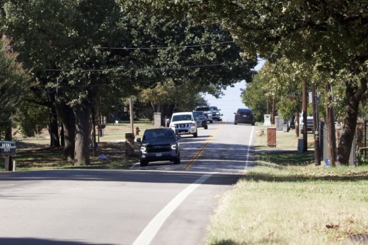 A car drives towards Ponderosa Street on Tinker Road