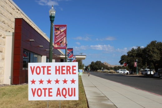 Outside Georgetown City Hall in downtown Georgetown, with a Vote Here sign.