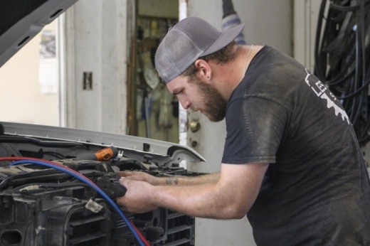 Mechanic Lucas Collier reassembles a truck that had a leaking AC condenser