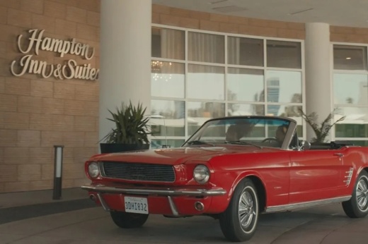 A red car outside a Hampton Inn.