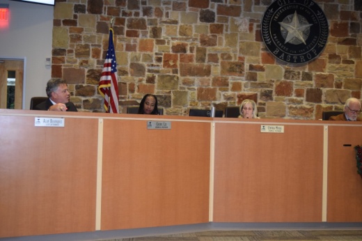 The dais is shown with the attorney, council member Cheryl Lee, council member Cynthia Meyer and mayor Lyle Nelson.