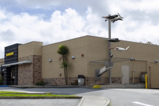 A rendering of a Zipline drone tower installed against the wall of a restaurant.