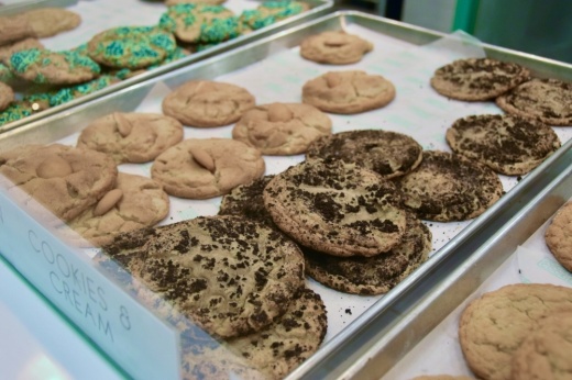 Cookies on trays in a display case.