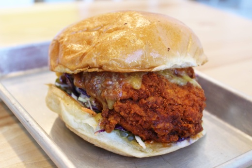 Chicken sandwich featuring biscuit and tan-colored sauce.