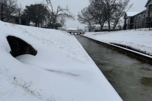 a partially frozen creek area with banks of snow