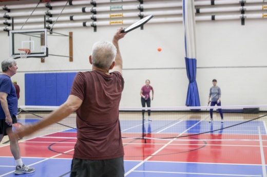The low-impact sport of pickleball can have numerous physical benefits, especially for people who have injuries, Robert Isles (center) said. (Elisabeth Jimenez/Community Impact)