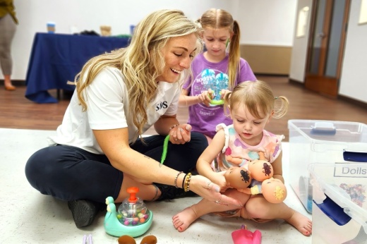A photo of a staff member interacting with children.