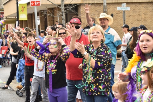 A parade crowd claps.