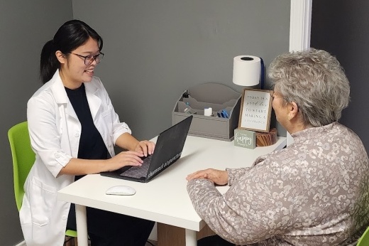 A woman sits down with a client at an acupuncture facility.