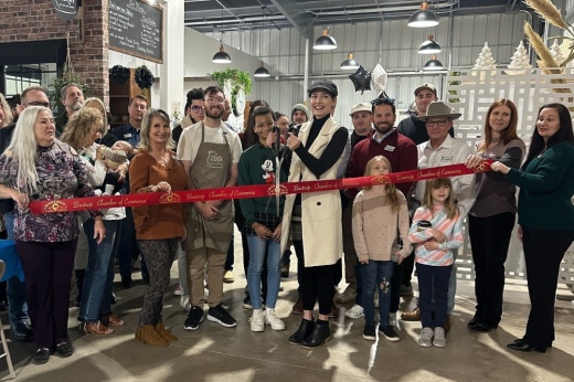 A group is shown cutting the red ribbon at the chamber event and grand opening party.
