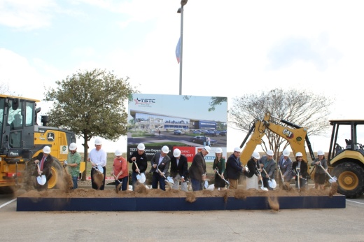 Officials shovel dirt at a groundbreaking.
