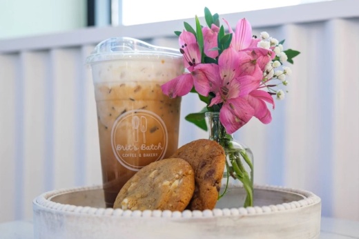 Cookies and a latte on a table with a flower
