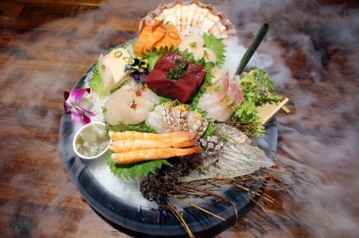 Sushi on a raised dish with dry ice under it.