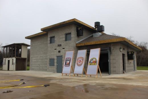 Image of a 2-story training building pictured behind stands displaying the logos of Flower Mound, Highland Village and Lewisville