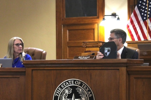 County Judge holds up body armor plate.