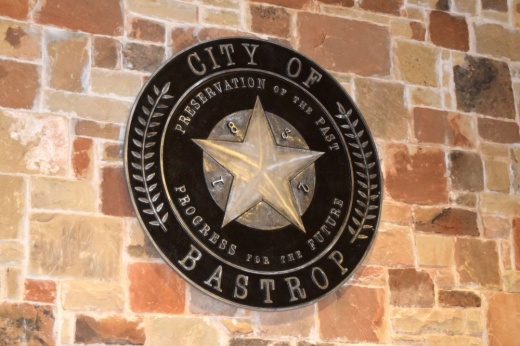 The city emblem is shown on a brick wall in city hall.