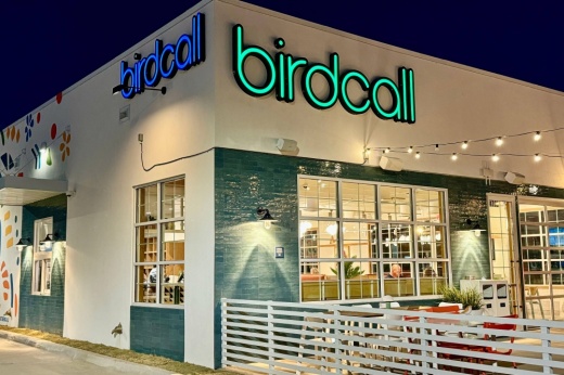 Night photo of an exterior of a building with Birdcall signage.