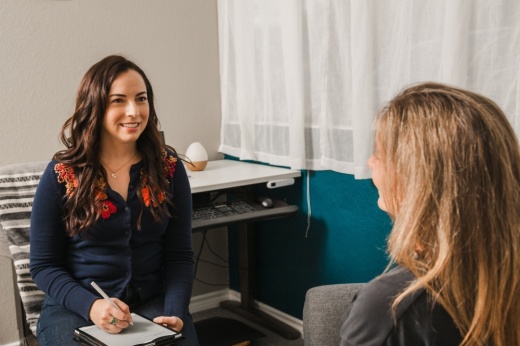woman talking to another woman during therapy session