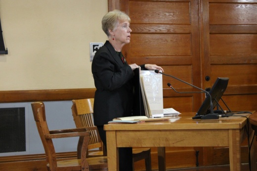 Woman holds up old court records.