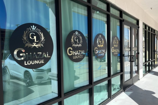Exterior of building with Ghaza Lounge signage stickers in each window.