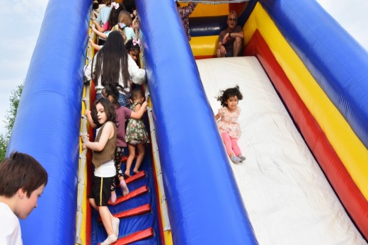 A photo of a child sliding down a bounce house.